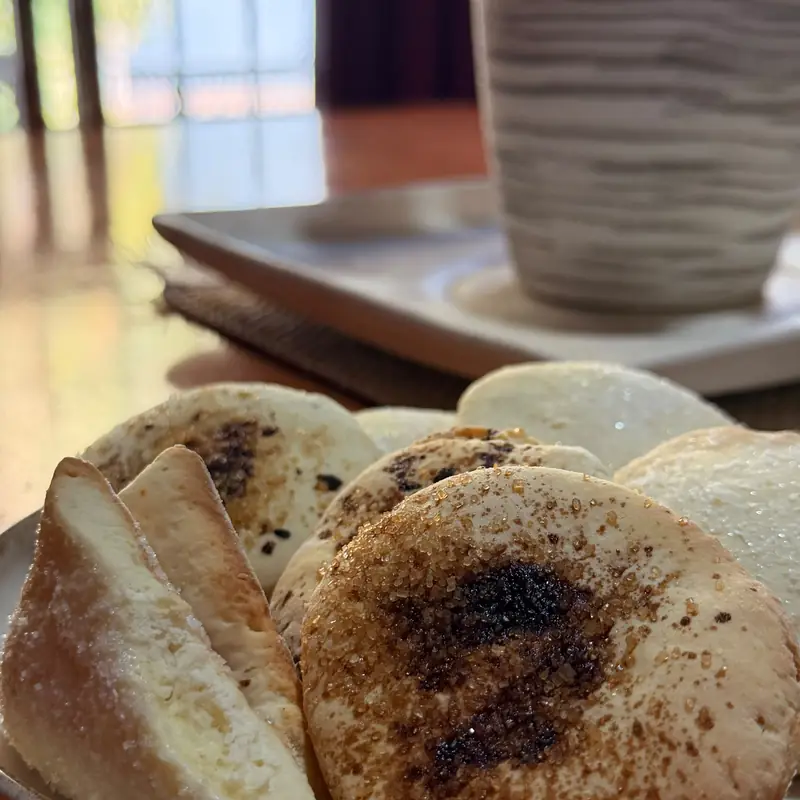 Tortitas caseras espolvoreadas con azúcar y una taza, servidas para la merienda